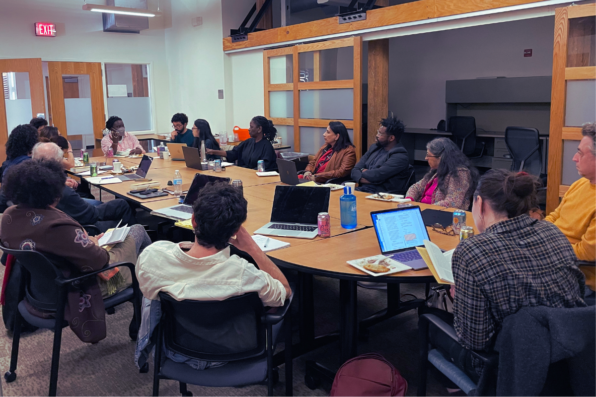 Faculty and students seated around table for seminar discussion