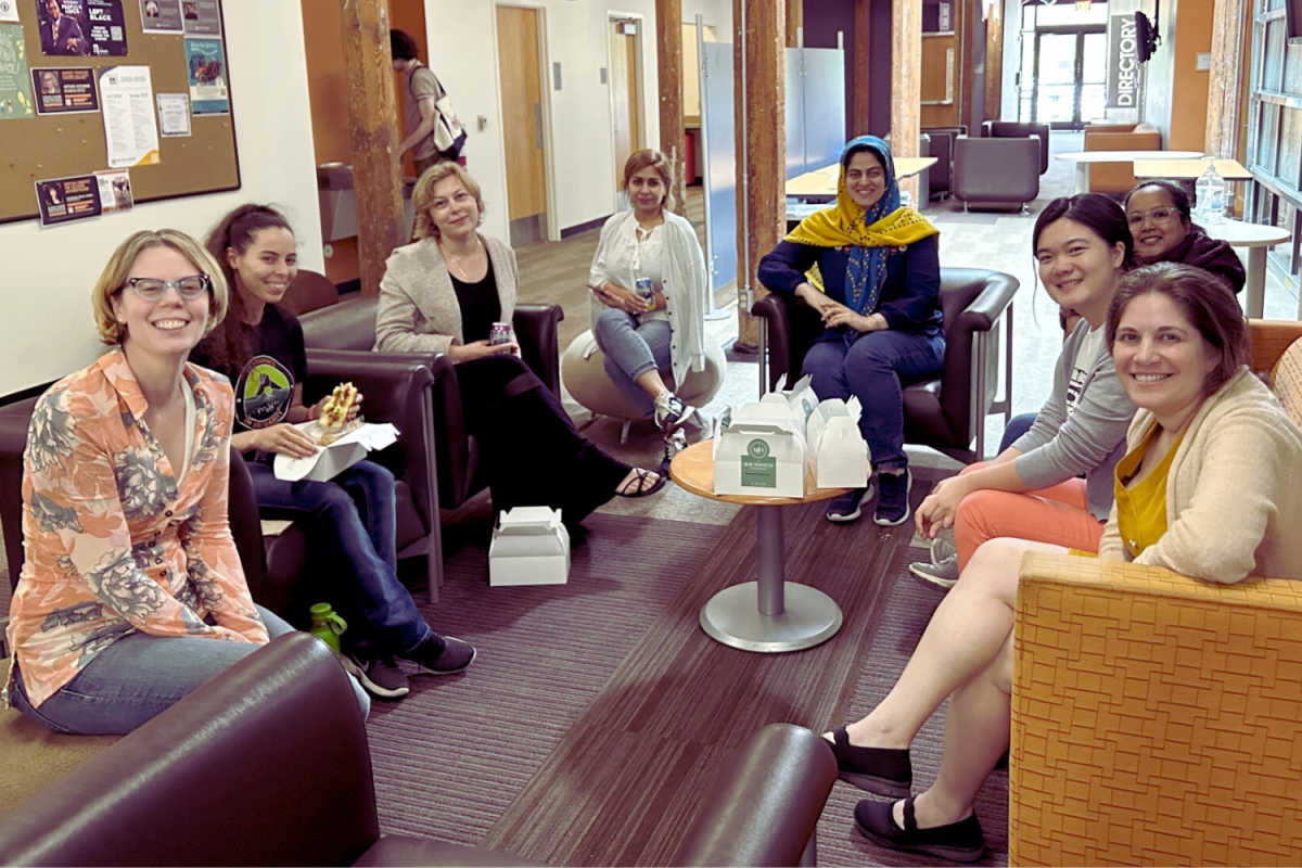 Group photo: eight women seated on couches, in semi-circle arrangement