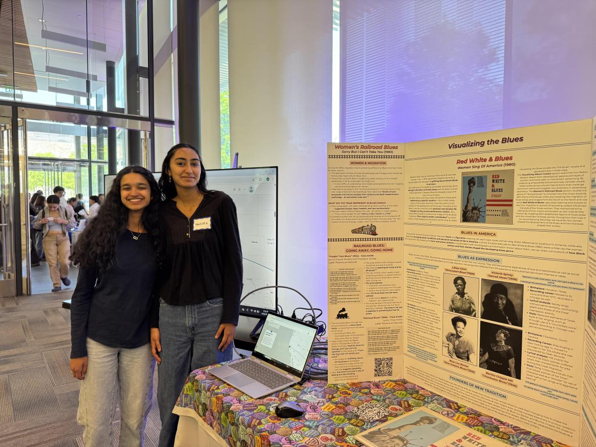 two students stand next to their presentation poster at an event at Duke University