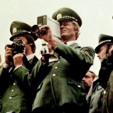 Film still from Germany in Autumn (group of military officers holding cameras)