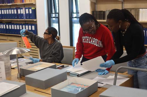 Three graduate students go through an archive or historical materials