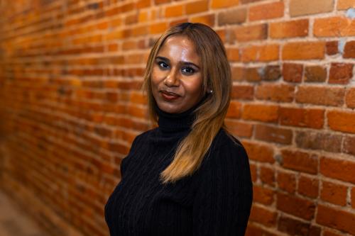 Portrait headshot of student standing in front of a brick wall